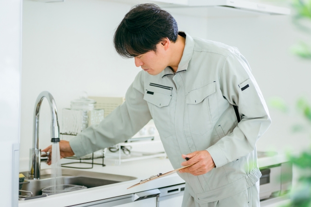 キッチンの蛇口をチェックしている作業員